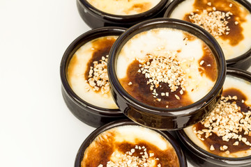 Traditional Turkish Style Baked Rice Pudding in casserole,clay dessert bowls,on white surface,close up