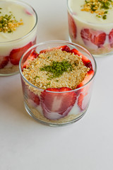 Magnolia puding dessert in transparent glass bowls on the white vertical surface