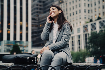 Happy businesswoman sitting and talking on phone