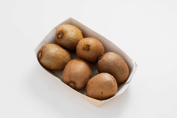 Kiwi in white pack, six fresh whole kiwi fruits, isolated. Top view.