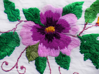 Embroidered flowers on the fabric. Ukrainian folk hand embroidery. On white background.	