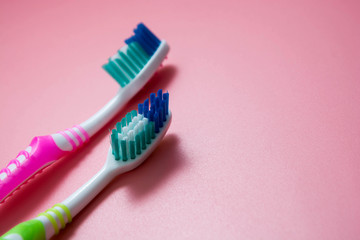 Two tooth-brushes over pink background. Dental hygiene care, copy space.