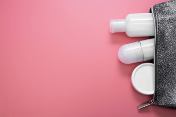 Beauty, cosmetics, hygiene products in cosmetics bag over pink background with copy space, flat lay skin care concept.
