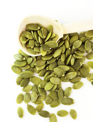 green pumpkin seeds with a wooden spoon