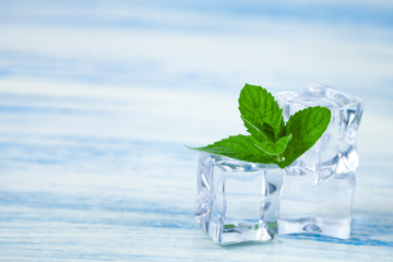 Ice and mint on a wooden table.