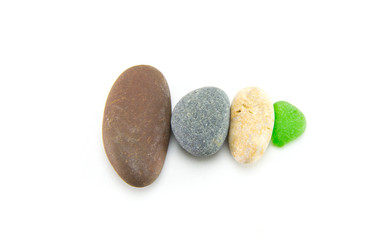 Four smooth, small stones (brown, white, gray and green) on a white isolated background. Sea or river pebbles of different sizes