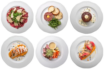Set of meat dishes: carpaccio, tartar, duck, turkey in white plates. Banquet dishes. Isolated on a white background.