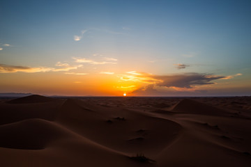 Fototapeta na wymiar Sun setting over horizon in desert