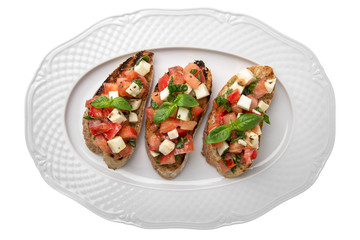 Tasty Vegetarian bruschetta with tomatoes and cheese. Easy cook, nutritious snack. Beautifully decorated catering banquet menu. Food snacks and appetizers for buffet. Isolated on white background.