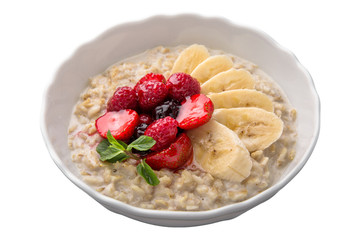 Healthy nutritious breakfast. Oatmeal with banana and berries with mint.
