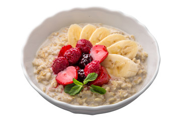 Healthy nutritious breakfast. Oatmeal with banana and berries with mint.