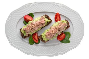 Tasty Vegetarian bruschetta with guacamole and tuna on rye bread. Easy cook, nutritious snack. Beautifully decorated catering banquet menu. Food snacks and appetizers for buffet. Isolated on white bac