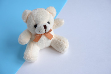 A beautiful beige  bear on a blue and white background. Soft toy.