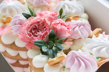 Close up cake decorated of pink roses and meringue