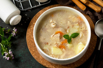 The concept of a healthy and diet food, tasty soup with chicken, cream cheese and cereals on a dark stone table. Copy space.