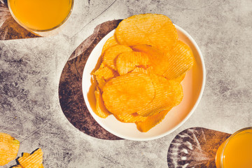 potato crisps served in a white bowl, beer snacks on a stone background. Toning