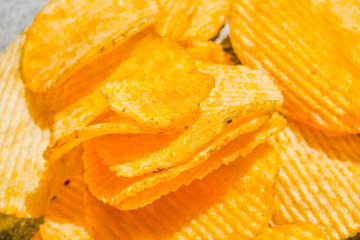 Background of potato crisps close-up. The texture of the corrugated crisps. Top view
