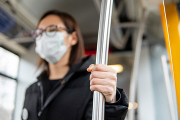 Portrait of young woman using public transport with mask