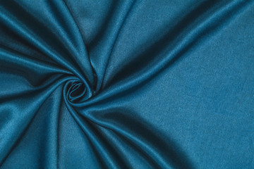 Smooth elegant blue silk or satin luxury cloth texture can be used as abstract background. Crumpled fabric Twisted at the side.