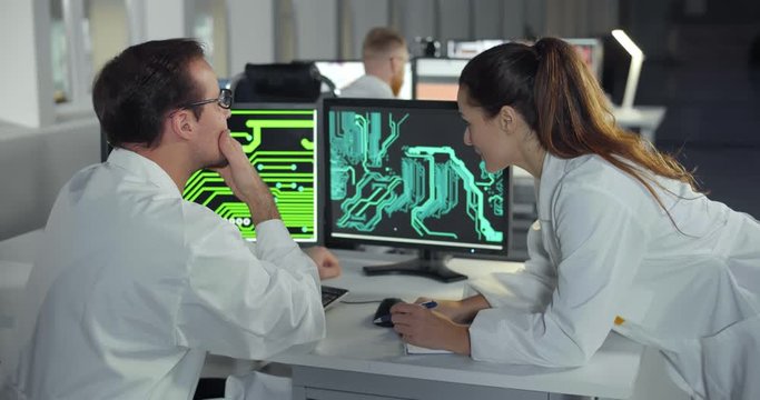 Female engineer helping colleague with detail drawing on computer