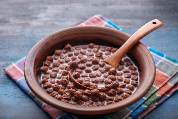 Crispy chocolate cereal balls with milk in a bowl. Healthy breakfast concept.