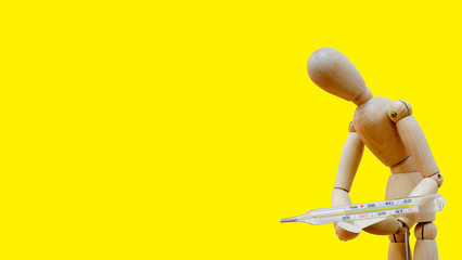 a wooden mannequin holds a thermometer in his hands, a sick man