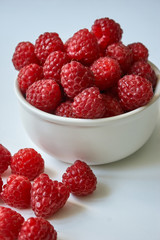 Red raspberries in a white plate.