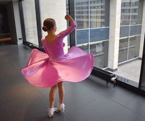 A girl in a lilac dress is engaged in ballroom dancing, whirls.