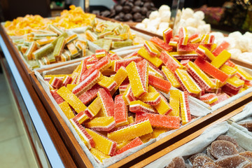 A bunch of colorful marmalade candies covered with sugar on the counter. Sale of sweets in a candy store.