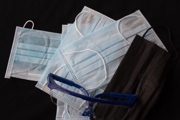 Close up shot of medical accessories on warm background. Plastic glasses and face mask supply during corona virus outbreak in Europe. Covid-19 concept, international crisis.