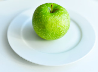 green Apple on a white plate