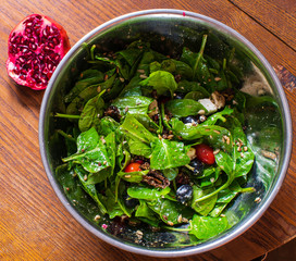 Salad made from fresh tomatoes, spinach, feta cheese, sunflower seeds, olives, olive oil, dried tomatoes, oregano.