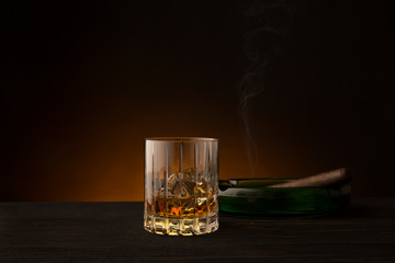 Whiskey on the rocks with cigar