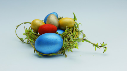 red and gold and blue Easter eggs in the nest