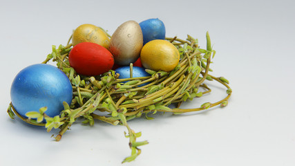 colorful Easter small quail eggs in a nest of young willow branches
