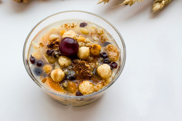 Traditional dessert  Noah's Pudding in transparent glass bowl on the white ground.