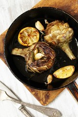 grilled artichoke with lemon in a pan.  Flatlay.  copy space. top view