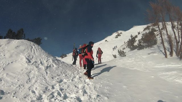 A group of friends hiking on the mountain top during a snow blizzard