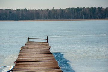 Obraz premium Closeup of the old pier on the frozen lake