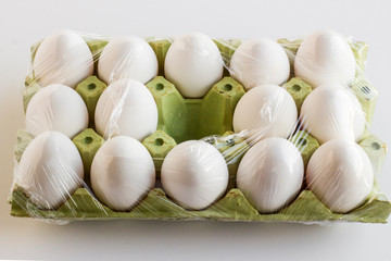 Fresh,organic white color eggs on the fifteen cardboard,wrapped in stretch film and a place is empty.