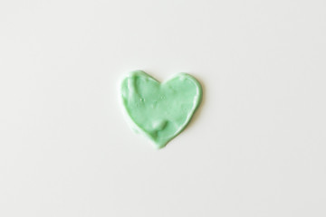 Heart from shampoo, cleanser or shower gel on white background. Concept hygiene and healthcare, top view