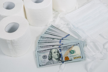 toilet paper rolls dollars and masks on a light background