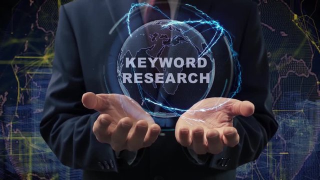 Male hands activate a conceptual holographic text Keyword research. Businessman in a suit with a hologram of planet Earth on a background of a futuristic wireframe city
