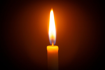 One light candle burning brightly in the black background 