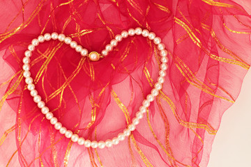 Pearl Necklace on the red tulle background.Conceptual image of special days.