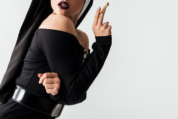 cropped view of sensual nun with marijuana joint isolated on grey
