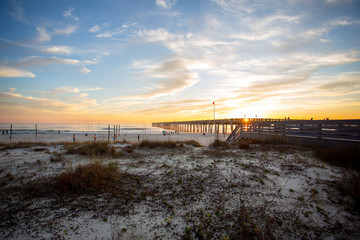 panama city beach florida ocean at shoreline with beautiul sunset clouds and pier into the water