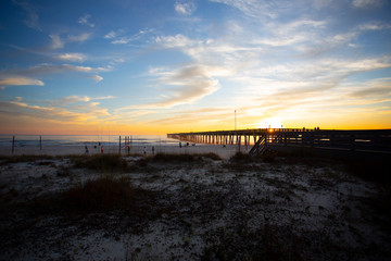 Obraz premium panama city beach florida ocean at shoreline with beautiul sunset clouds and pier into the water