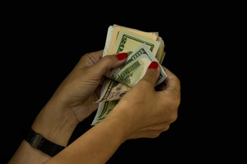 Red nail polish hands counting dollar banknotes on black background with copy space