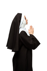 beautiful nun praying with closed eyes and hands together isolated on white